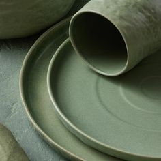 two green plates with one empty plate on the side and another in the middle, sitting next to each other