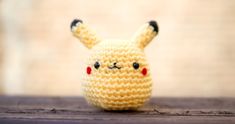 a small crocheted pikachu doll sitting on top of a wooden table