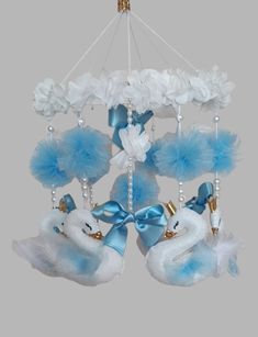 a chandelier with swan decorations hanging from it's sides and blue feathers