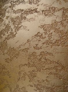 the wall is covered in brown and tan paint, with small spots on it's surface