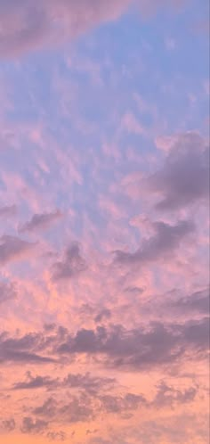 an airplane is flying high in the sky at sunset or dawn with pink clouds and purple hues