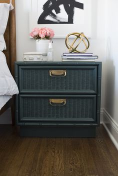 a nightstand with two drawers and a painting on the wall