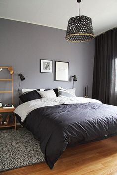 a bedroom with grey walls and white bedding