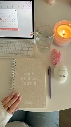 a woman sitting at a desk with a notebook and candle