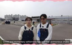 two young men standing next to each other in front of a building with pink flowers