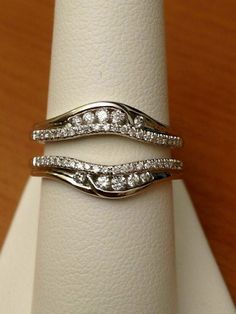 two wedding rings sitting on top of each other