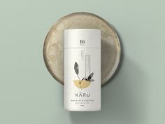 a can of karu tea sitting on top of a metal plate next to a green wall