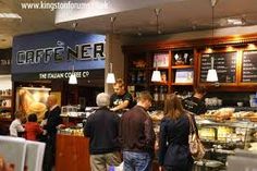 people are standing in line to get food from the counter at cafe ner, which is open for business