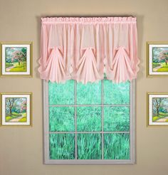 the window is decorated with pink curtains and pictures on the wall behind it, along with green grass