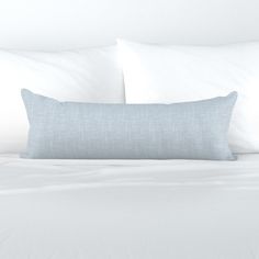 a white bed with two pillows on top of it