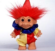 a troll doll with red hair and blue collar