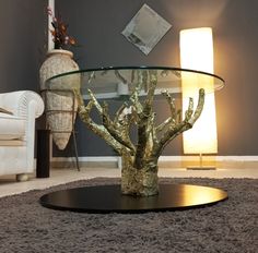 a glass table topped with a tree on top of a rug