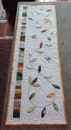 a table with a white and orange quilt on it