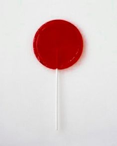 a red lollipop sitting on top of a white table