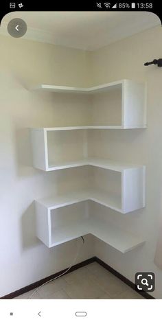 an empty room with white shelves on the wall