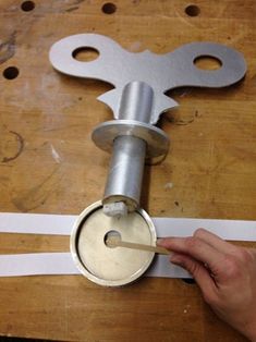 a person is working on a metal object with white tape around it and a wrench in the middle