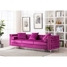 a purple couch sitting in front of a book shelf