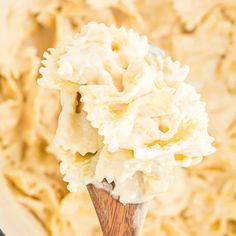 a wooden spoon filled with mashed potatoes in a white bowl on top of a table