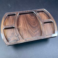 a wooden tray with two compartments on it and one section divided from the other side