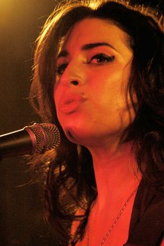 a woman singing into a microphone on stage