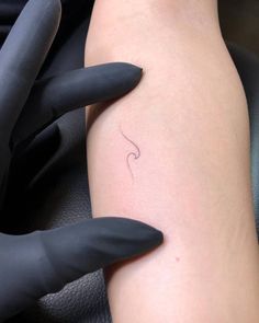 a woman's arm with a small tattoo on it