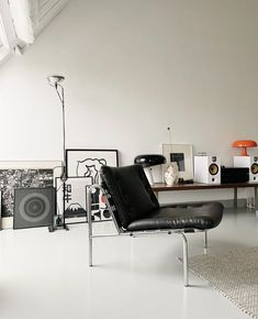 a living room filled with furniture and speakers on top of a white floor next to a window