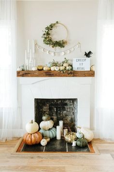 the fireplace is decorated with pumpkins and candles