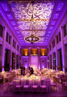 an elegant ballroom with purple lighting and white linens on the ceiling is pictured in this image