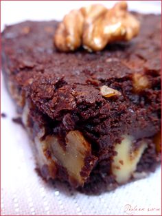 a piece of chocolate dessert with nuts on top