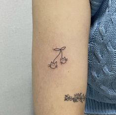 a small tattoo on the arm of a woman's left arm with two birds