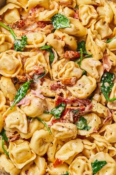 a bowl filled with pasta and spinach on top of a table