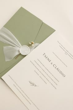 a wedding card with a white ribbon on it and a button attached to the front