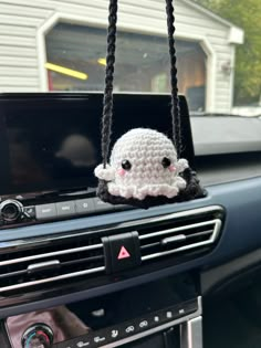 a car dashboard with a stuffed animal hanging from the dash board