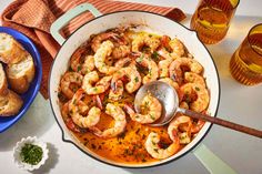 a pan filled with shrimp and bread on top of a table