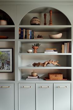 a book shelf filled with lots of books and knick knacks on top of it