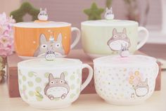 four different mugs with cartoon animals on them