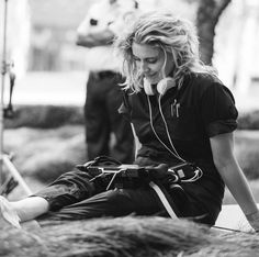 a woman sitting on the ground listening to headphones