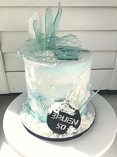 a white and blue cake sitting on top of a table