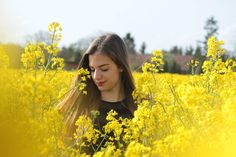 a woman standing in a field of yellow flowers