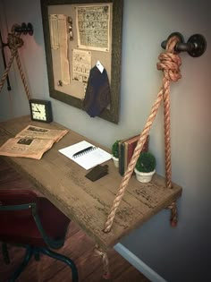 a wooden desk topped with a notebook and rope