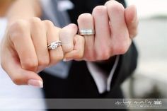 black and white photograph of a woman holding her engagement ring in one hand with the other