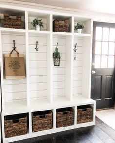 an entryway with white shelves and baskets