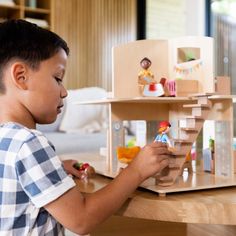 a young boy playing with his doll house