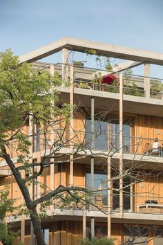 an apartment building with balconies and trees in the foreground