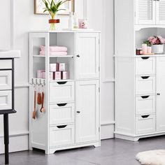 a room with white furniture and pink flowers on the shelf, along with other items