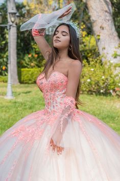 a woman in a pink and white dress is holding her hand up to her head