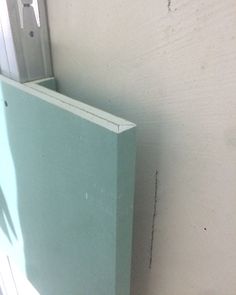 the corner of a room that has a door and window frame on it, in front of a white wall