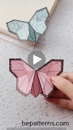 someone is holding an origami butterfly