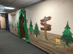 an office hallway decorated in the theme of winnie the pooh with trees and signs