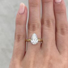 a woman's hand with a ring on it and a diamond in the middle